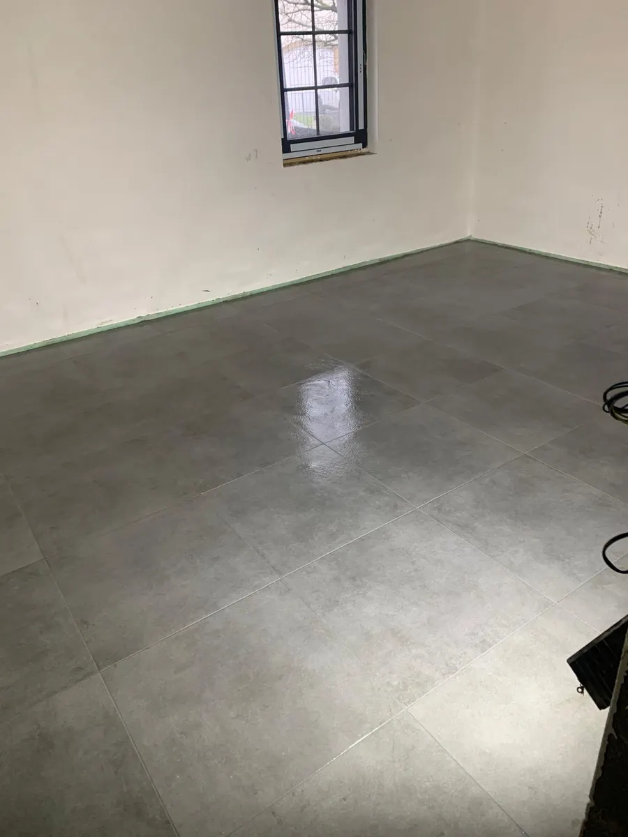 Slaapkamer met grootformaat grijze betonlook vloertegels