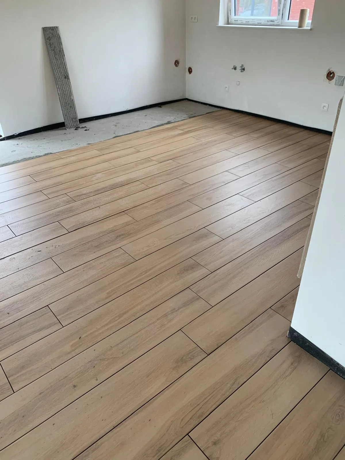 Light oak wood-effect floor tiles laid in a staggered pattern