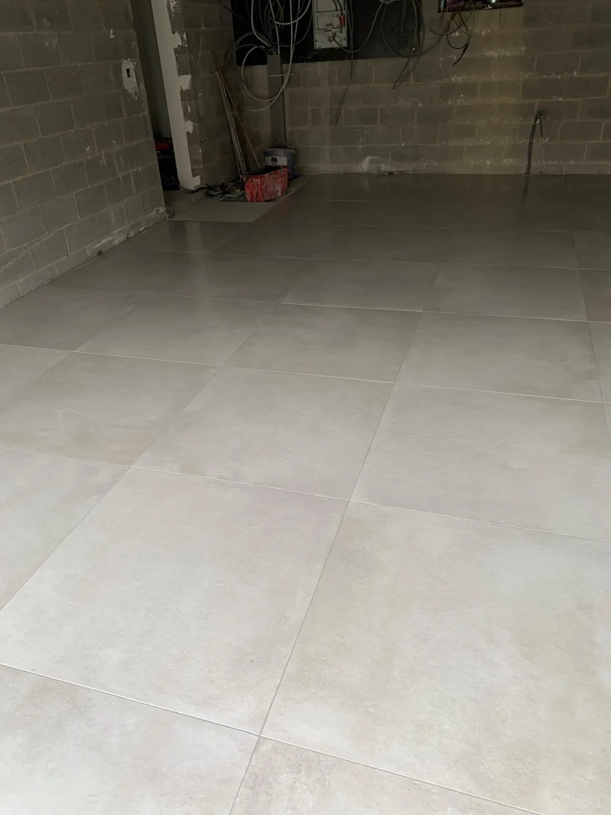 Garage floor in large light grey tiles laid and grouted