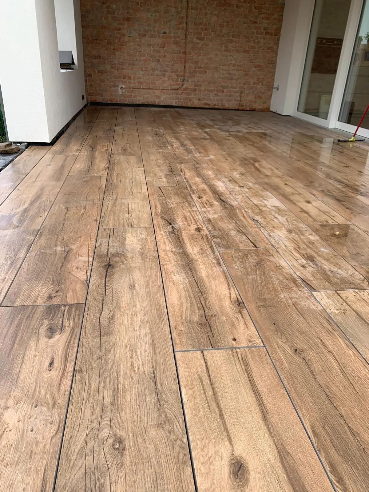 Covered terrace tiled with natural oak wood-effect planks