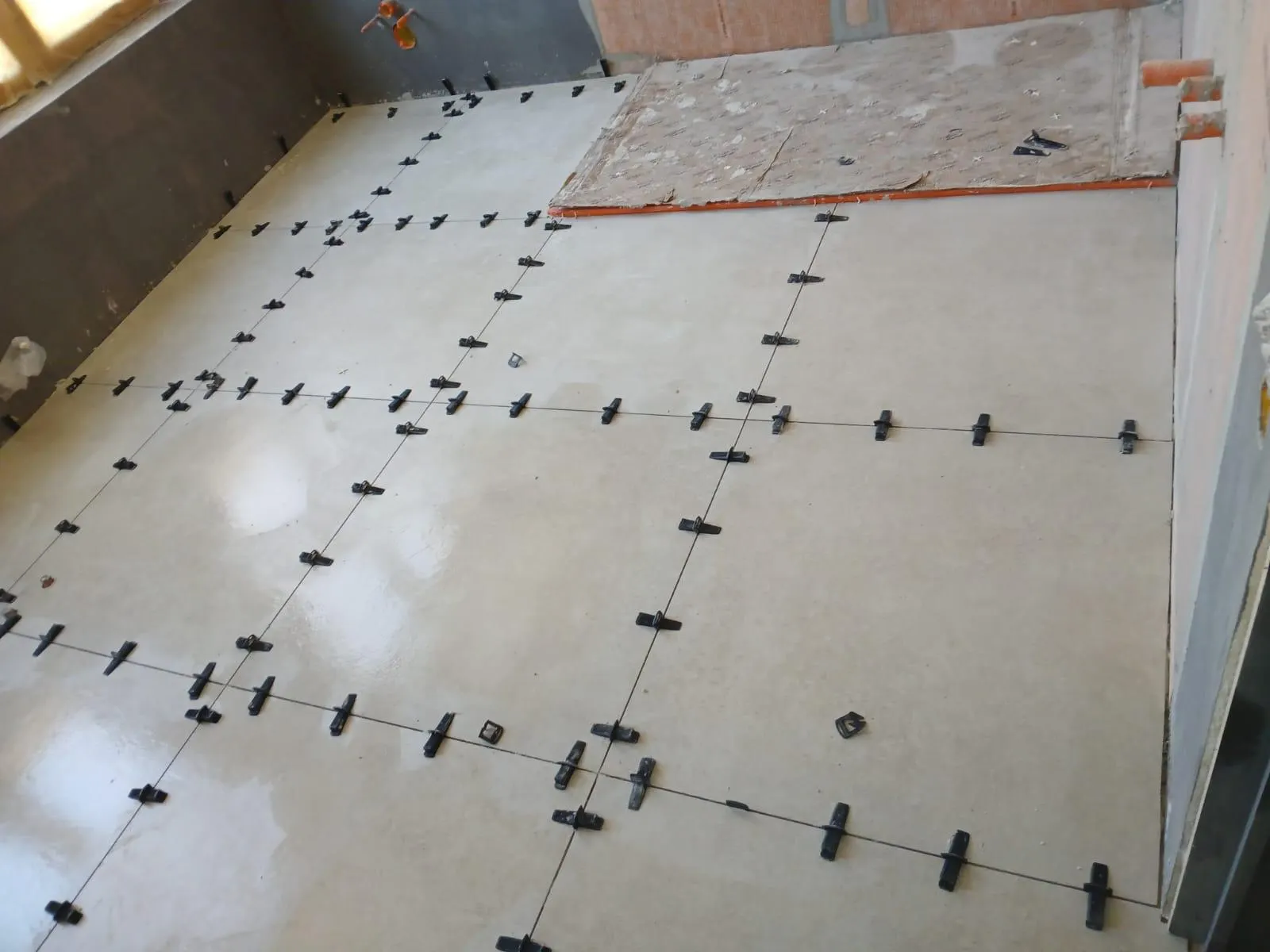 Dalles grand format beige avec croisillons autonivelants pendant la pose