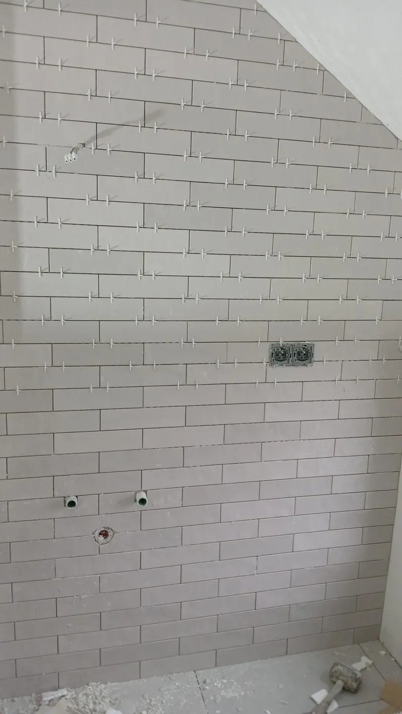 Mur en briquettes format métro gris clair posées à joints décalés