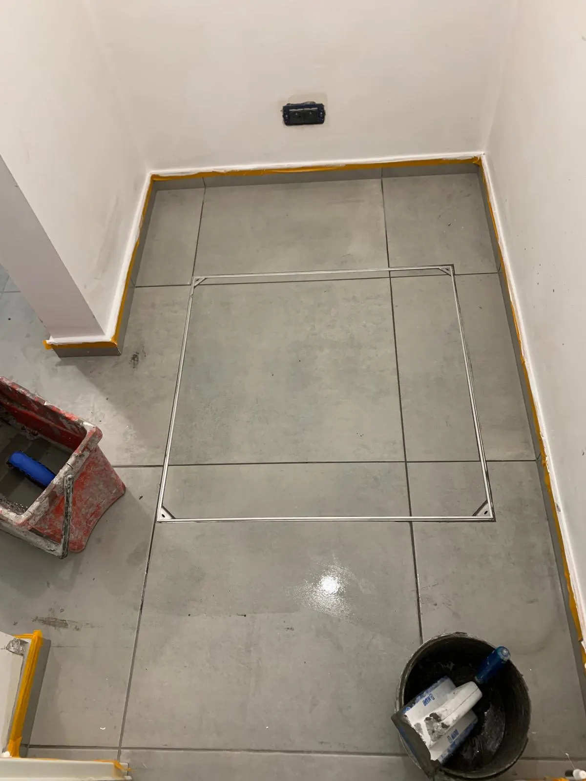 Trappe de visite inox affleurante intégrée dans un carrelage gris