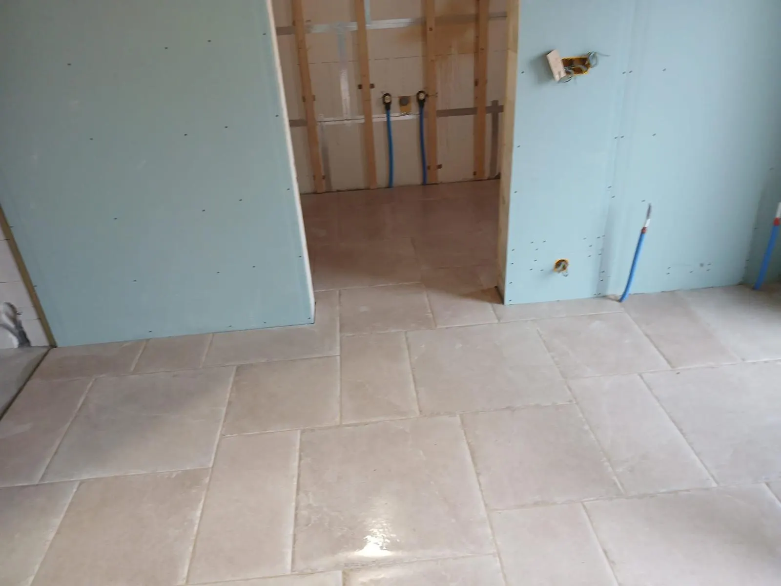 Vloer in taupe steenlook tegels in een aanbouw in opbouw