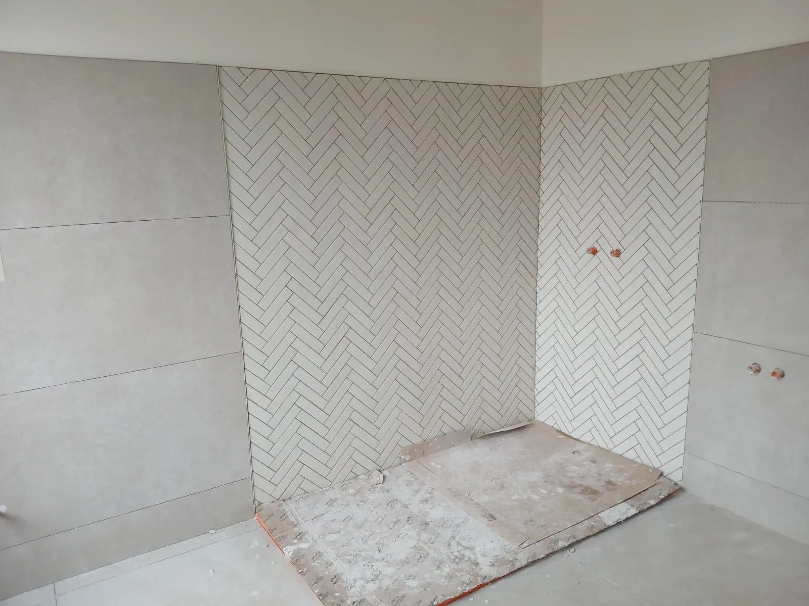 Witte wandtegels in visgraatverband in een badkamer