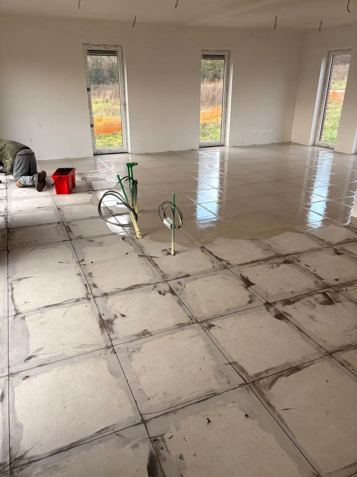 Voegwerk in uitvoering op een beige tegelvloer in een nieuwbouwwoning