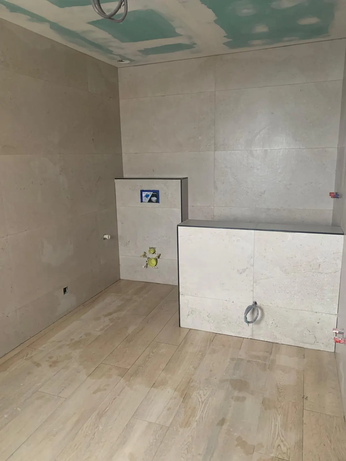 Badkamer met travertinlook wanden en vloer in lichte houtlook