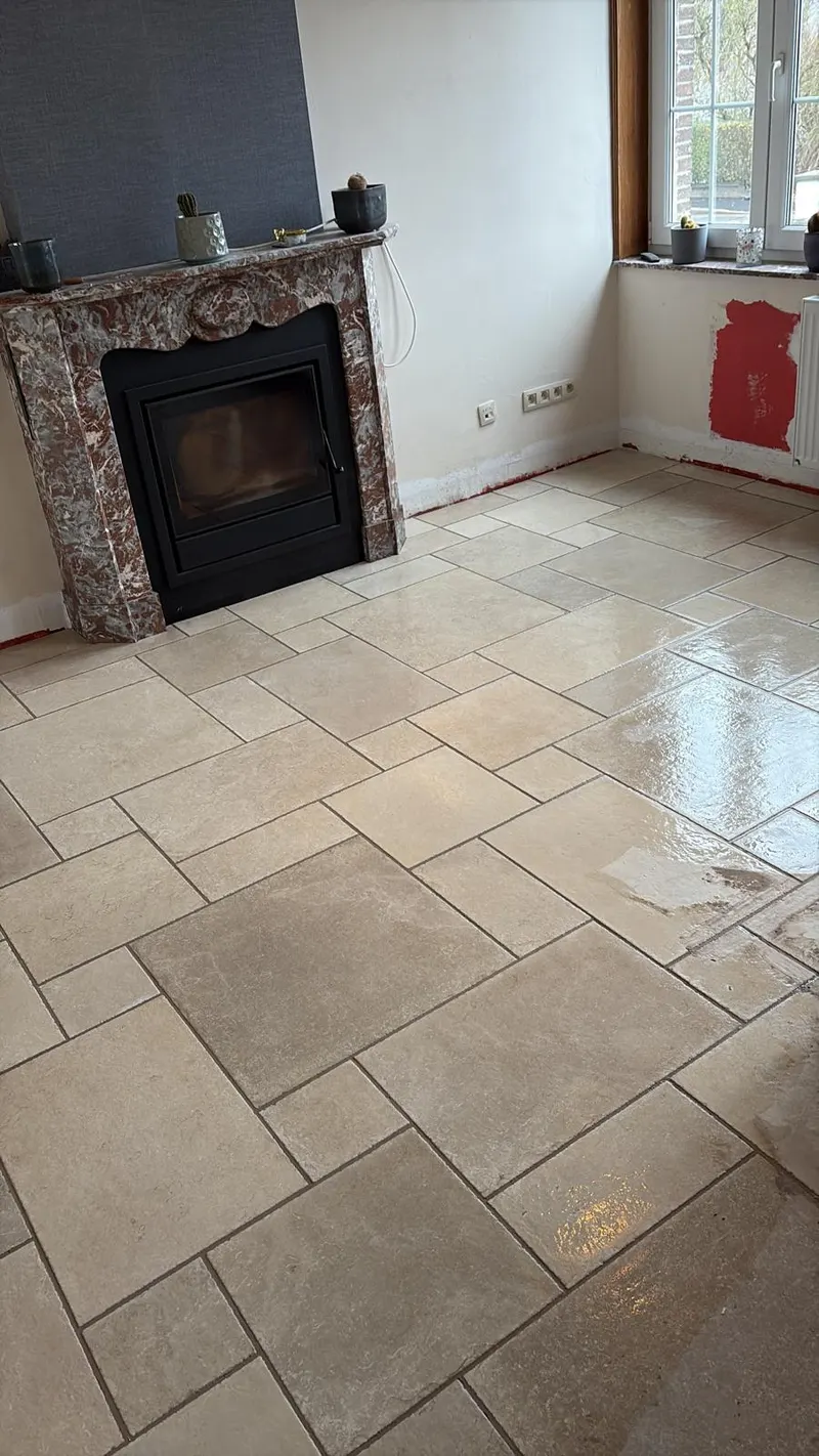 Salon met marmeren schouw en beige natuursteenlook tegels in wildverband