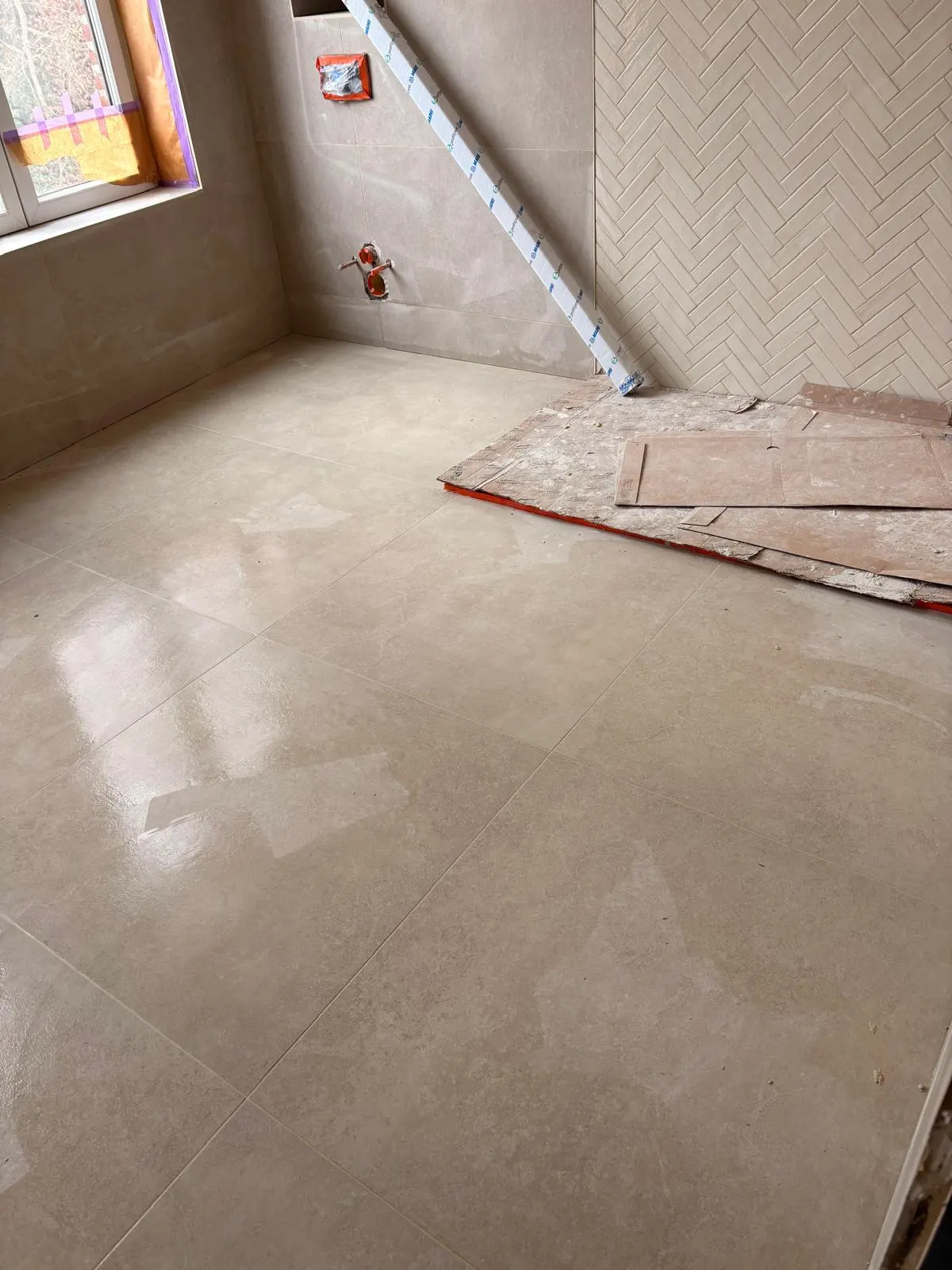 Vloer met beige marmerlook groot formaat en visgraatwand in een badkamer